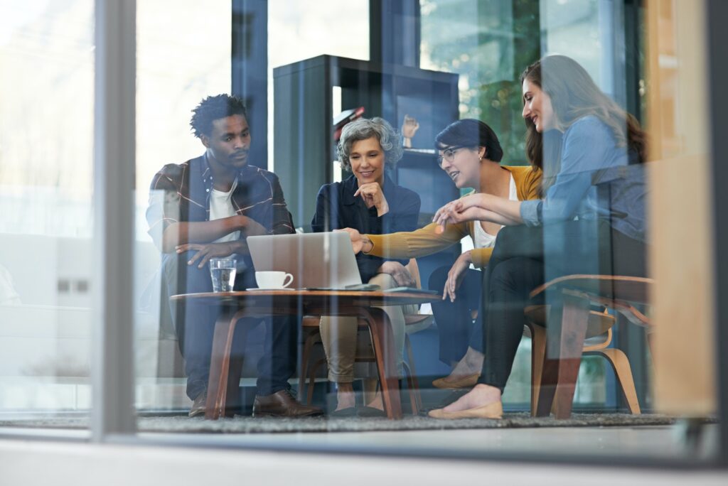 Shot of a team of creative businesspeople brainstorming around a laptop in the office